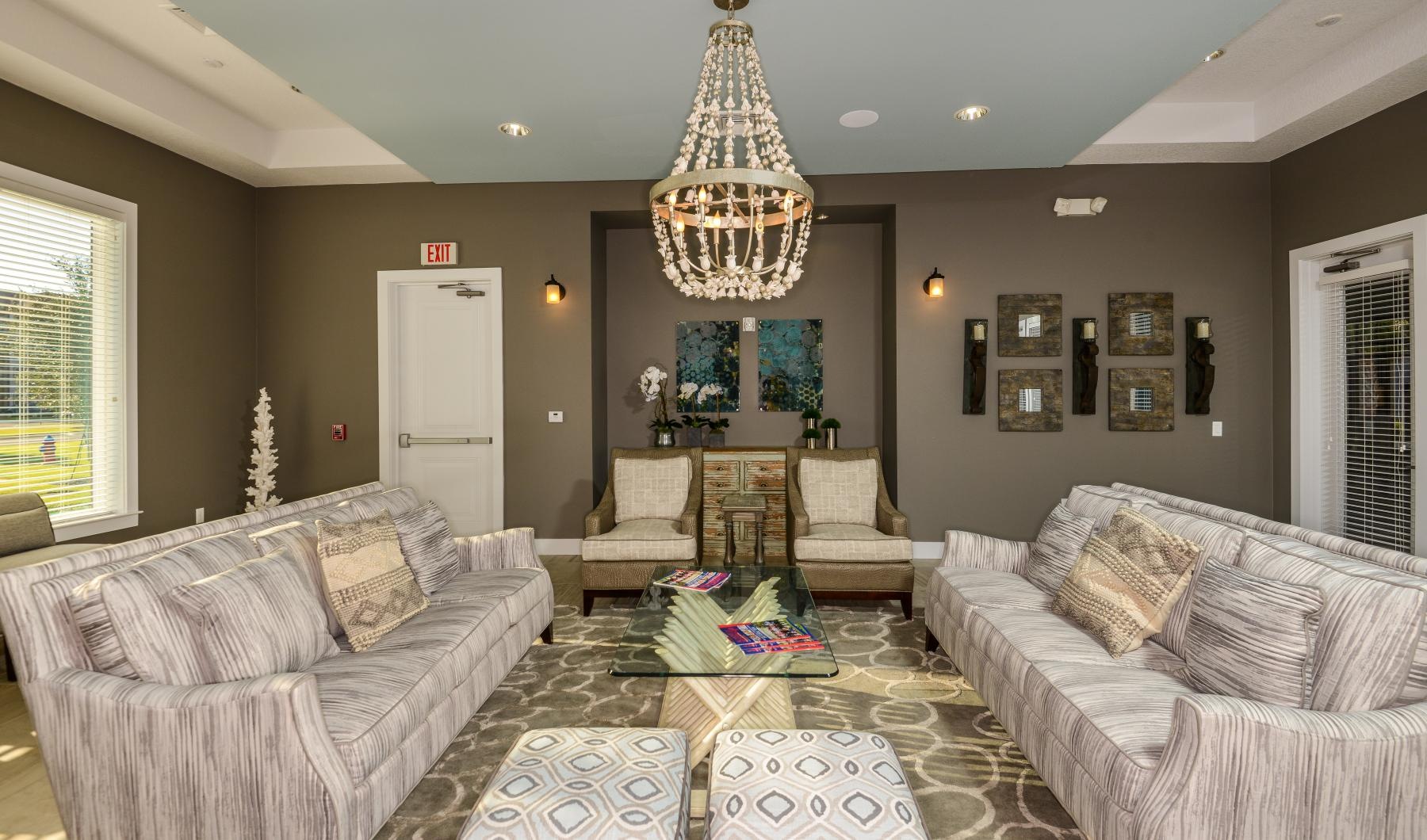 a lounge with a chandelier and couches